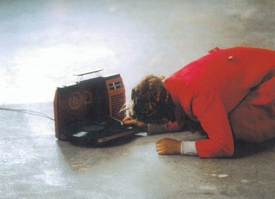 Die Performancekünstlerin Christine Bänninger beugt sich während einer Aktion hin zu einem auf dem Boden liegenden Plattenspieler