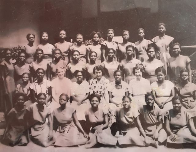 Gruppenfoto einer Abschlussklasse von jungen Schwarzen Frauen und drei Weissen