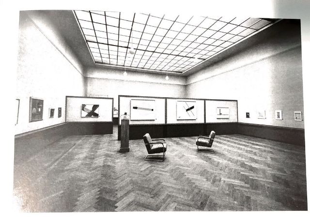 Installationsansicht  der Ausstellung 'Konstruktivisten' in der Kunsthalle Basel. Ganz im Hintergrund, von den Stellwänden fast verdeckt, die Werke Sophie Taeuber-Arps.