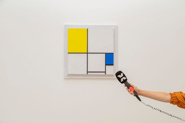 Ein Mikrofon von Radio X wird vor ein Bild von Mondrian gehalten