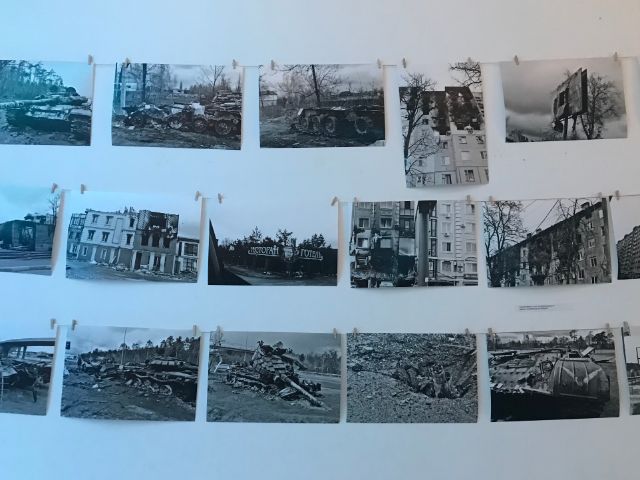 Es sind Fotos von zerbombten Häusern und Panzern auf den Strassen zu sehen.