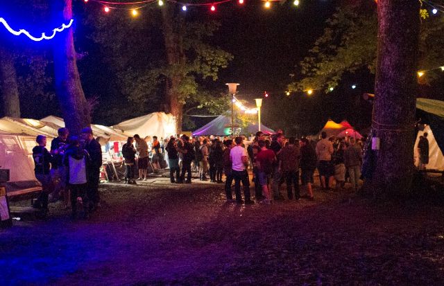 Girlanden und beleuchtete Zelte mit vielen Menschen am Holzrock Festival