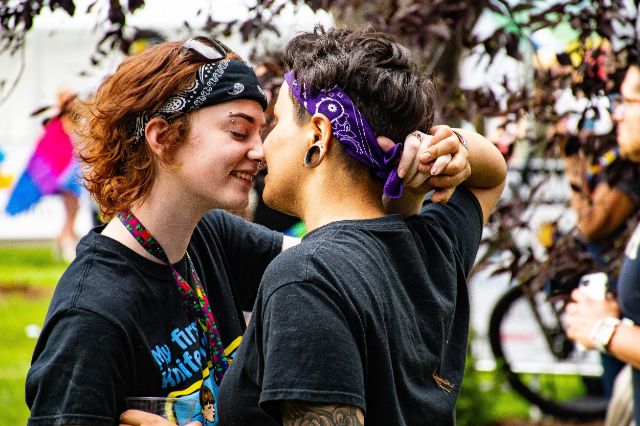 Zwei queere Personen zeigen sich Nähe und sind kurz davor, sich zu küssen.
