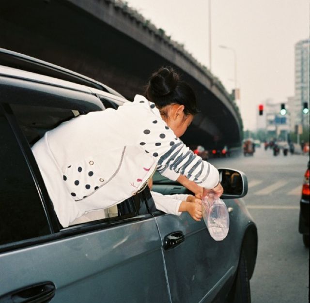 maedchen beugt sich aus fahrendem auto. von Jiajia Zhang