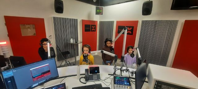 vier Kinder an den Studiomikrofonen von Radio X