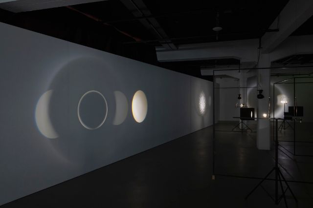Lichtprojektionen als Planeten im gebauten Mini-Kosmos von Pe Lang.