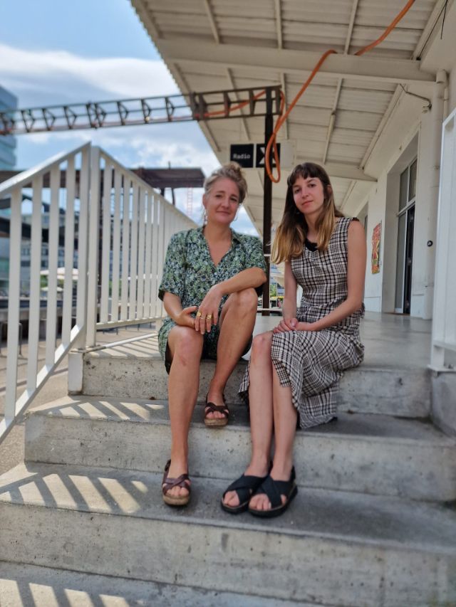 Die beiden Künstlerinnen sitzen auf der Treppe vor dem Radio X Studio.