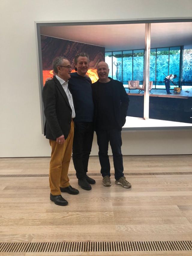 Drei Männer stehen vor einem Kunstwerk