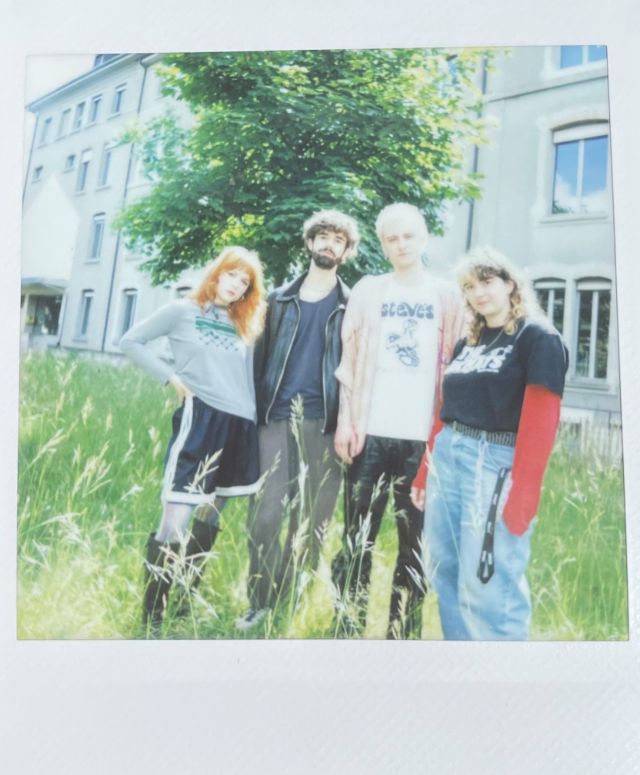 vier menschen stehen im gras