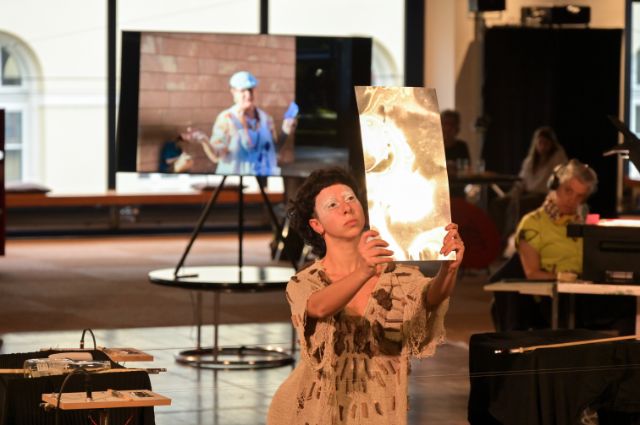 eine performance einer frau mit einem stück metall