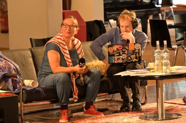 zwei personen, mit mikrofon und laptop auf einem sofa