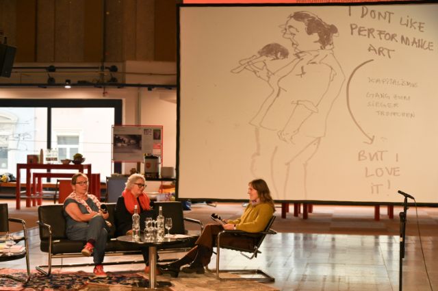 drei personen in einem saal sitzend