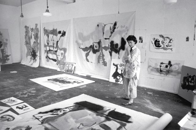 die künstlerin im atelier mit mehreren leinwänden