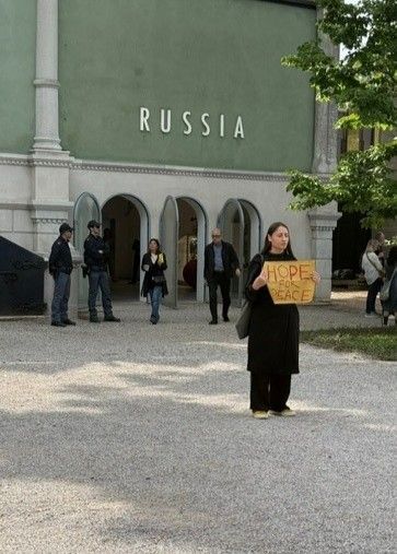Eine Frau protestiert leise gegen die Teilnahme von Russland an der Biennale