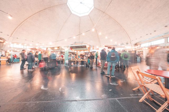 Das Kuppeldach der Markthalle beherbergt viele Stände und Tische