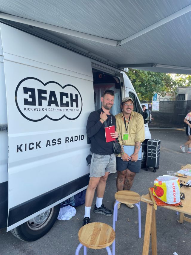 2 menschen posieren vor dem radio bus