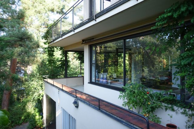 Ein Wohnhaus mit Terrasse , mit Rebe teilweise überwachsen, Blick in die Wohnräume