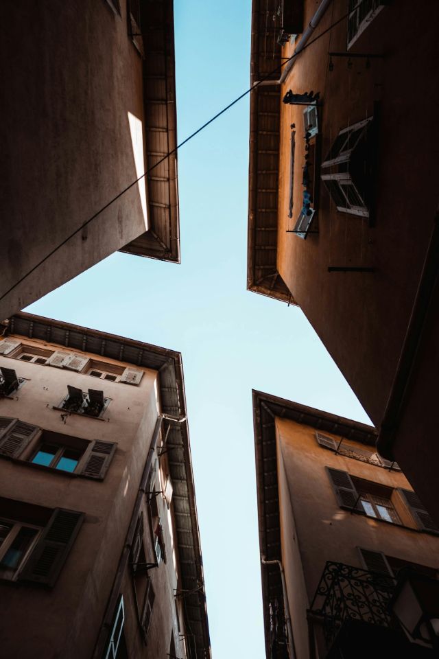 Blick nach oben himmelwärts in einer engen Gasse.